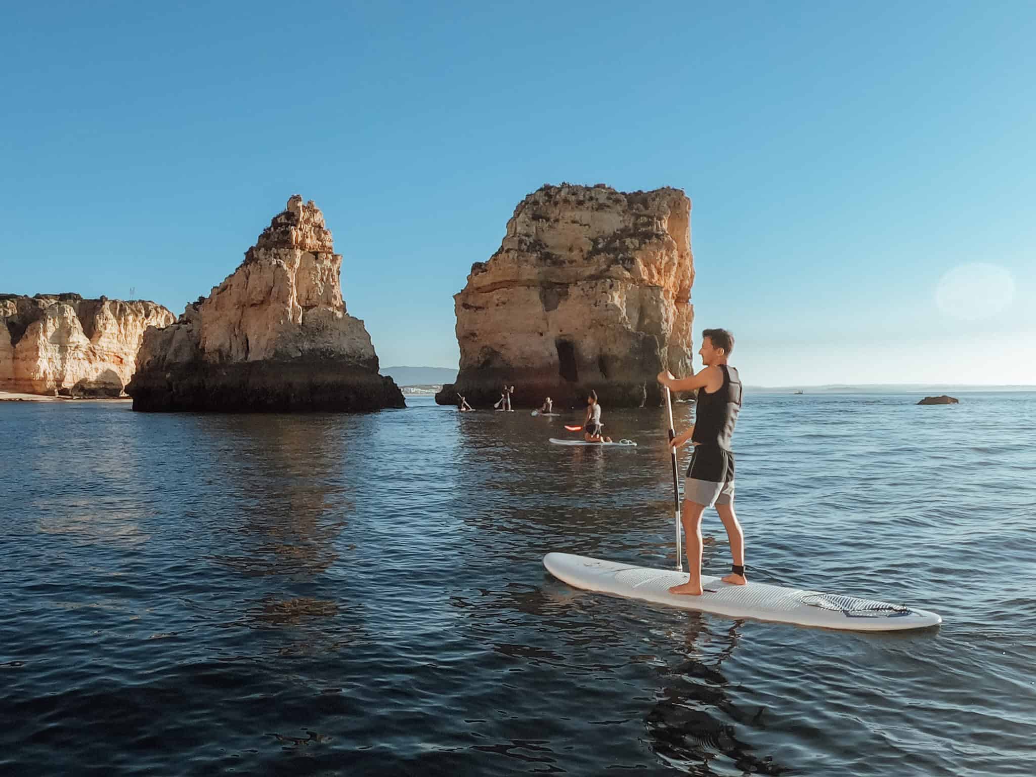 Guided group exploring the limestone sea caves and rock arches of Lagos on stand-up paddleboards