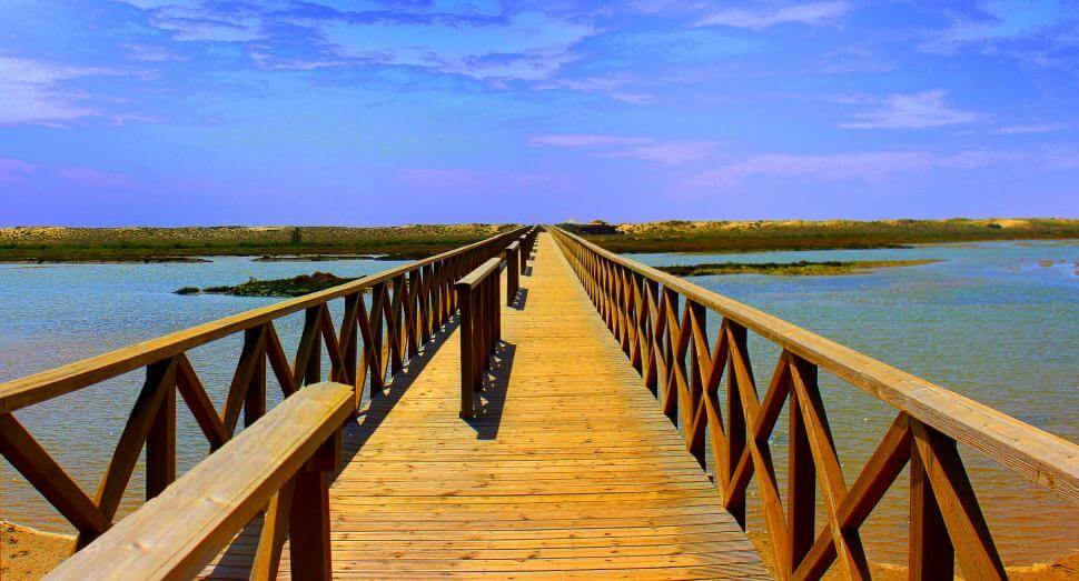 The long wooden pedestrian bridge crossing over the Ria Formosa lagoon at Quinta do Lago beach