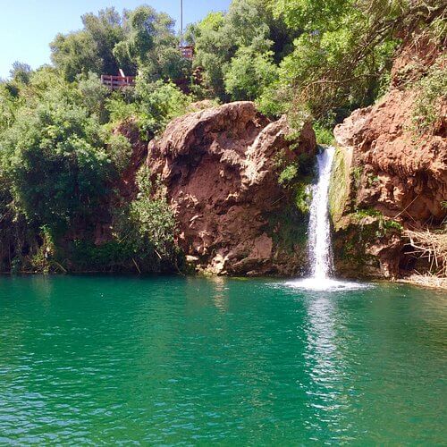 The secluded emerald green waterfall pool hidden in nature at Pego do Inferno near Tavira