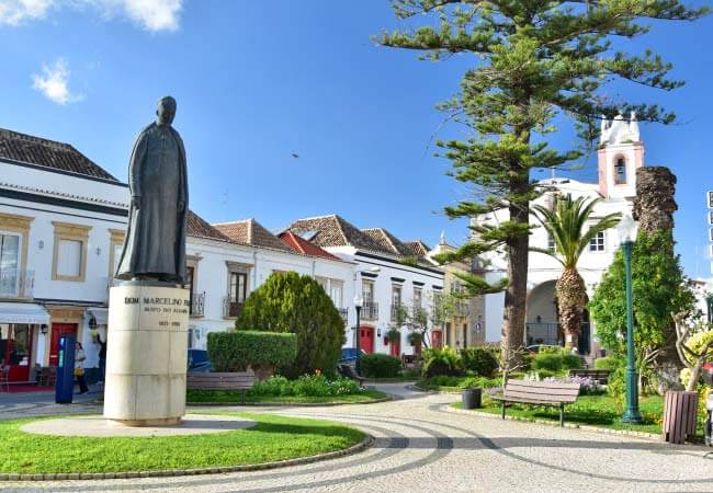 Shaded benches and elegant traditional architecture framing the peaceful Jardim da Alagoa square in Tavira
