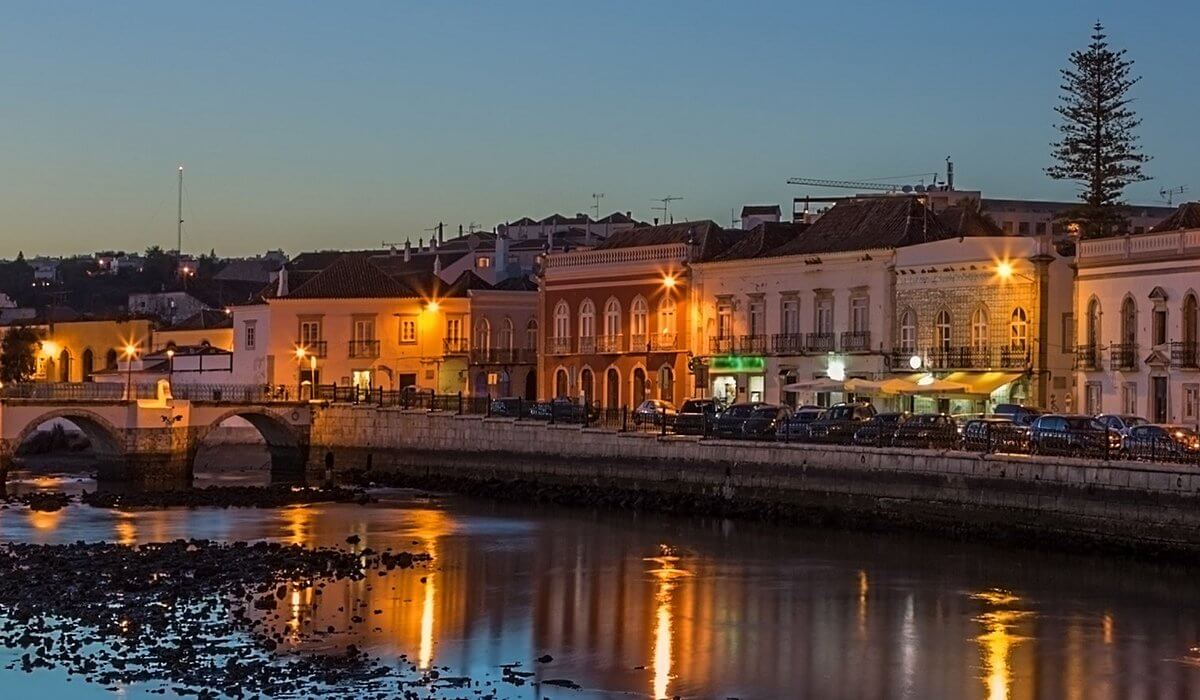 Illuminated historical Roman Bridge over the Gilão River at night in Tavira